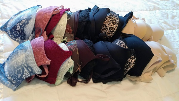 collection of used bras on bed