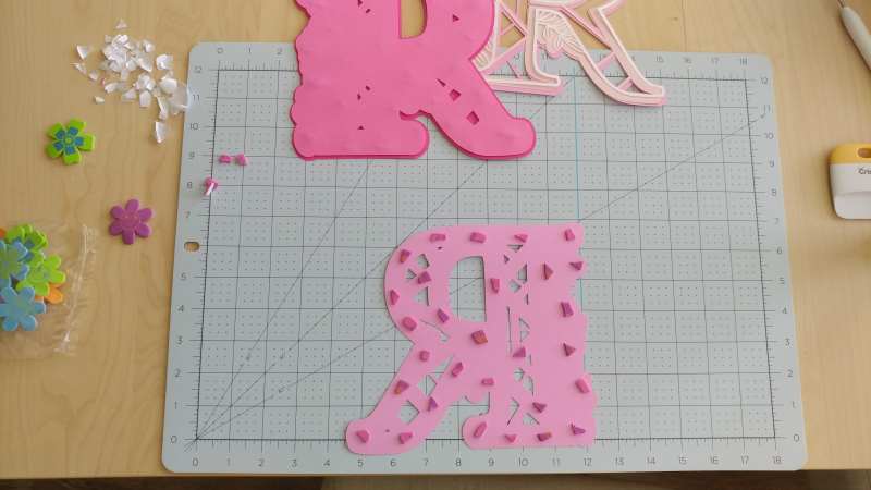 layers of pink paper letter R cut with a Cricut machine with pieces of foam stickers